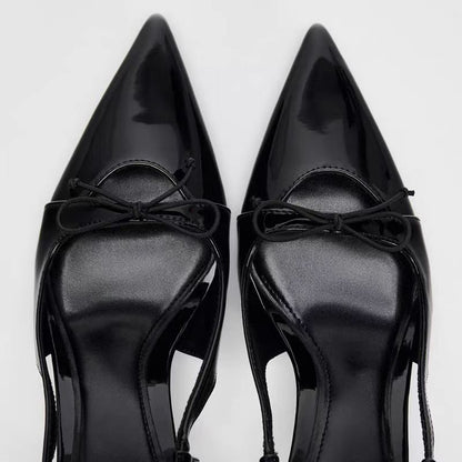 Black patent leather bow with pointed tip thin heel and a shallow strap for women's sandals