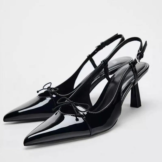 Black patent leather bow with pointed tip thin heel and a shallow strap for women's sandals